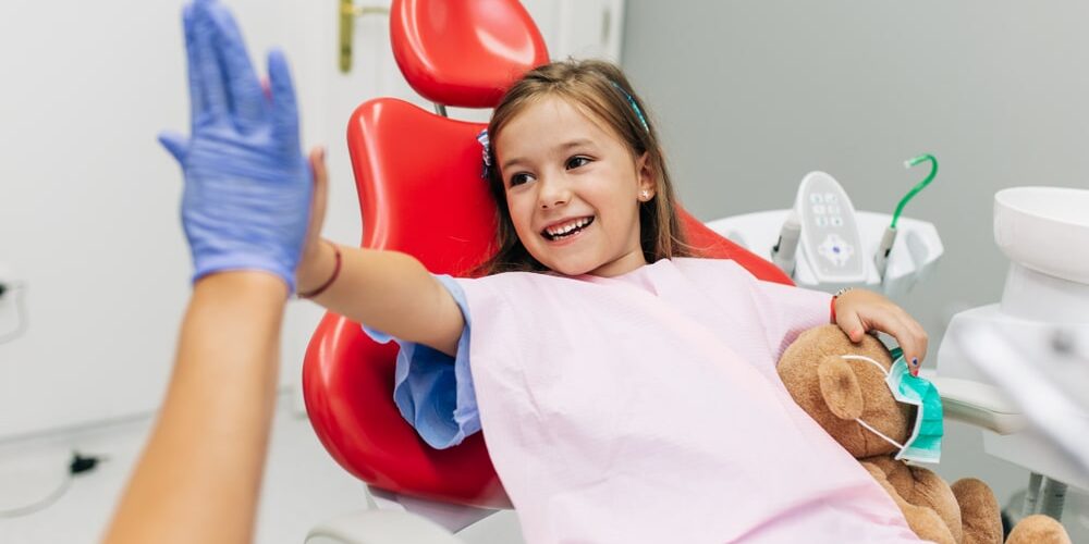 child high fiving her dentist