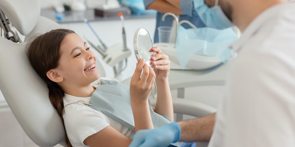 girl looking in the mirror after dental procedure