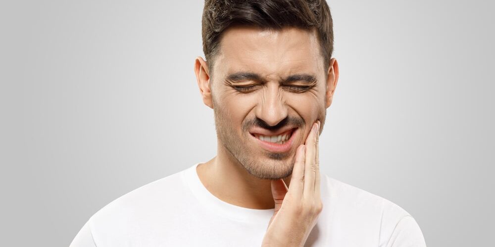 Man holding his jaw in pain