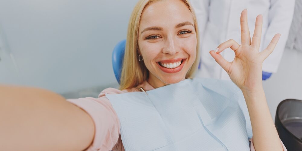 Blonde Woman smiling happily in dentist chair